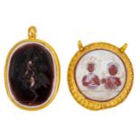 Two intaglio pendants, comprising: a circular hardstone intaglio pendant depicting the profile of