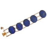 A lapis lazuli and gold bracelet, composed of a series of five oval lapis lazuli cameos, each carved