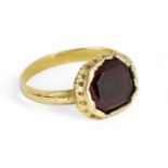 A garnet ring, centring on a mixed-cut octagonal garnet, inset to a textured mount, ring size K,