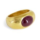 A ruby ring, in the Roman style the wide tapering band inset with an oval cabochon ruby, ring size