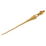 A 19th century gold stickpin, terminating in the figure of a gladiator on a tapering triform base,