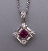 An 18 ct white gold ruby baguette and brilliant cut diamond pendant on an 18 ct white gold chain.