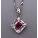 An 18 ct white gold ruby baguette and brilliant cut diamond pendant on an 18 ct white gold chain.