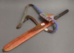 A tribal dagger in sheath with bead work belt. 53 cm long.