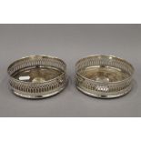 A pair of silver mounted bottle coasters. 13.5 cm diameter. 10.1 troy ounces total weight.