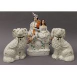A pair of Staffordshire dogs and a Staffordshire flatback clock group. The latter 36 cm high.