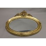 A modern gilt framed oval mirror. 105 cm wide.