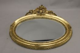 A modern gilt framed oval mirror. 105 cm wide.