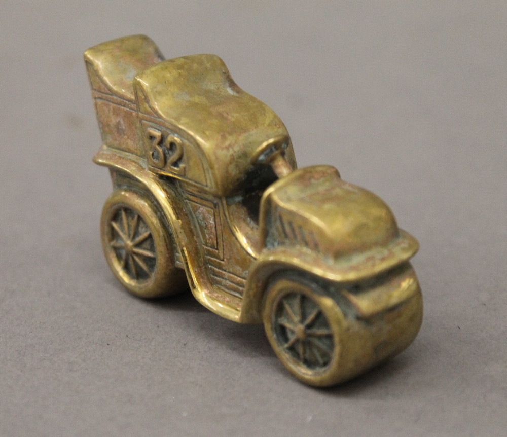 A brass vesta formed as a vintage car. 6 cm long.