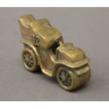 A brass vesta formed as a vintage car. 6 cm long.