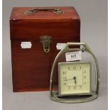 A stirrup form clock in a wooden box. The clock 14 cm high.