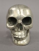A silver plated model of a skull. 9 cm high.