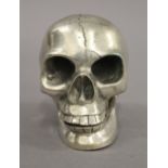 A silver plated model of a skull. 9 cm high.