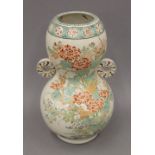 A 19th century Oriental pottery double gourd vase, brightly decorated with flowers and rockwork. 31.
