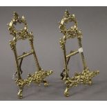 A pair of brass easels. 29.5 cm high.