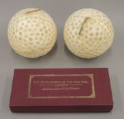 Two large golf ball candles and a boxed Development of the Golf Ball Set. Each candle 15 cm high.