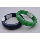 A Chinese carved jade bangle and another. The former 7.25 cm diameter.