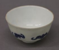 A Chinese porcelain tea bowl decorated with bats. 8 cm diameter.