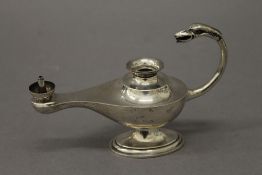 A silver table lighter formed as an oil lamp. 14 cm long. 106.8 grammes total weight.