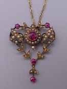 An Edwardian 9 ct gold seed pearl and red stone set pendant, on 9 ct gold chain. The pendant 4.