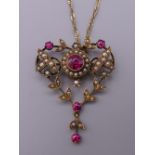 An Edwardian 9 ct gold seed pearl and red stone set pendant, on 9 ct gold chain. The pendant 4.