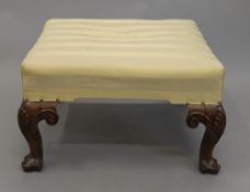 A Georgian style upholstered walnut footstool. 61 cm wide.