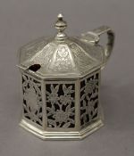 A Georgian silver octagonal engraved and pierced mustard pot with cranberry glass liner. 8 cm high.