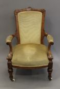 A Victorian upholstered walnut open armchair. 68 cm wide.