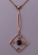 A 9 ct rose gold pearl and garnet lavalier pendant necklace. 2.9 grammes total weight.