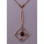 A 9 ct rose gold pearl and garnet lavalier pendant necklace. 2.9 grammes total weight.