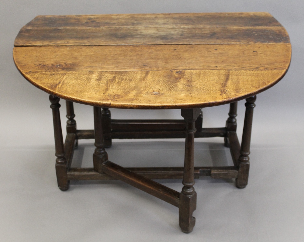An 18th century oak drop leaf table. 111 cm wide. - Image 2 of 3