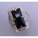 An Art Deco onyx and diamond white gold cocktail ring. Ring size N/O. 13.