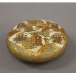 A 19th century Satsuma box decorated with figures. 9.5 cm diameter.