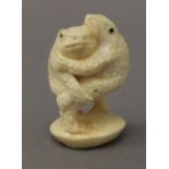 A carved bone netsuke formed as two toads. 5 cm high.