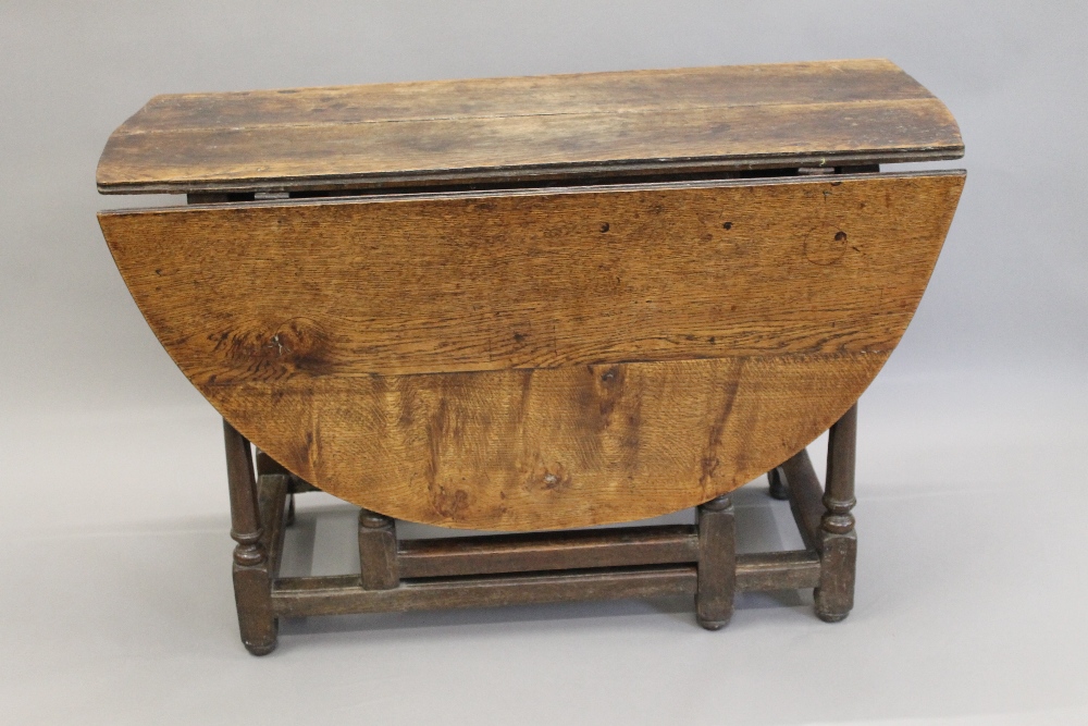 An 18th century oak drop leaf table. 111 cm wide.