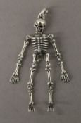 A silver skeleton form pendant. 7 cm high.