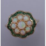 A 9 ct gold, opal and emerald ring. Ring size L/M. 2.6 grammes total weight.