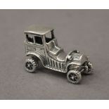 A silver model of a car. 3 cm long.