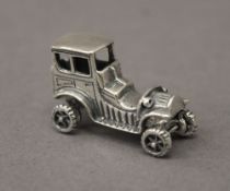 A silver model of a car. 3 cm long.