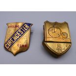 A brass and enamel decorated Cirencester Cycling Club badge and a brass clip decorated with a penny