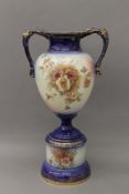 A Victorian porcelain twin handled vase on stand. 59 cm high.