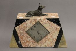 An Art Deco mantle clock surmounted with a dog. 32 cm high.