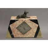 An Art Deco mantle clock surmounted with a dog. 32 cm high.