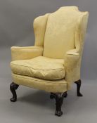 An 18th century style upholstered wingback armchair. 87 cm wide.