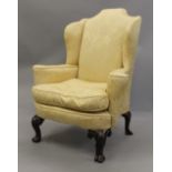 An 18th century style upholstered wingback armchair. 87 cm wide.