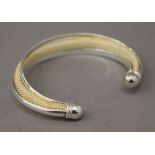 A silver torque bangle. 7.5 cm wide. 29.