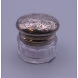 A small unmarked white metal mounted glass vinaigrette,