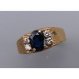 An unmarked gold diamond and sapphire ring. Ring size N/O. 5.5 grammes total weight.
