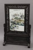 A Chinese porcelain screen on wooden stand. 67.5 cm high.