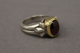 An unmarked gold and silver garnet ring. Ring size L.